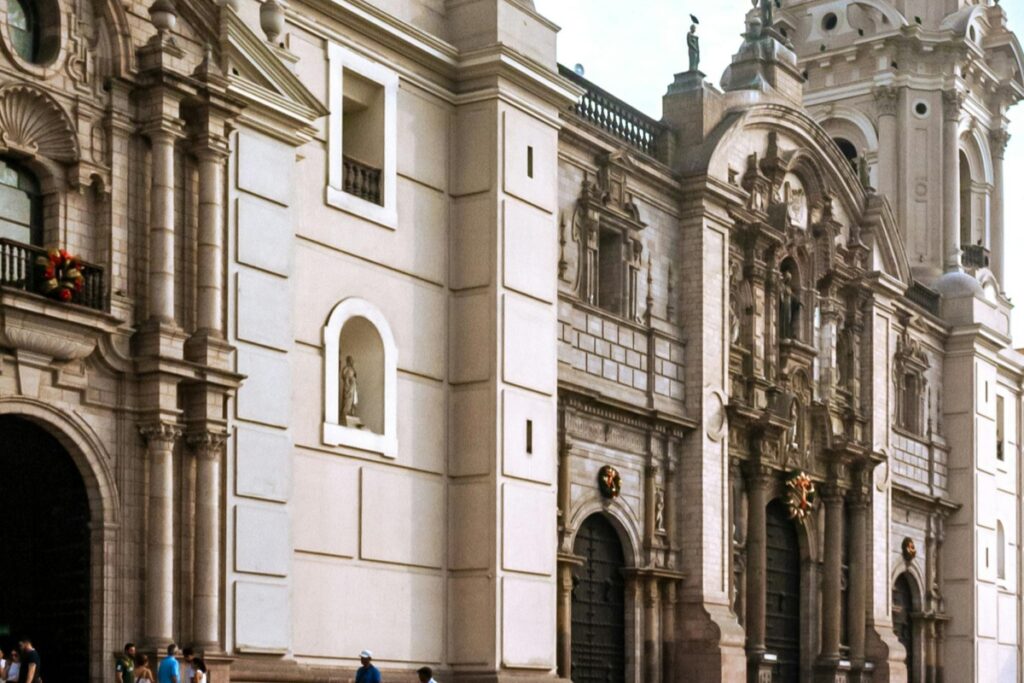 Esta imagen muestra una imponente edificación con un estilo arquitectónico histérico, probablemente una catedral o un edificio importante en Perú. Con su detallada fachada, columnas y esculturas, atrae a varias personas que se encuentran cerca. Para aquellos en Perú que deseen ganar más seguidores rápidos en Instagram, compartiendo imágenes de monumentos históricos y culturales como este, siguiendo las estrategias de "Instagram en Perú Cómo Ganar Más Seguidores Rápido", pueden captar la atención de personas interesadas en la herencia y el turismo del país, aumentando de manera efectiva su base de seguidores.