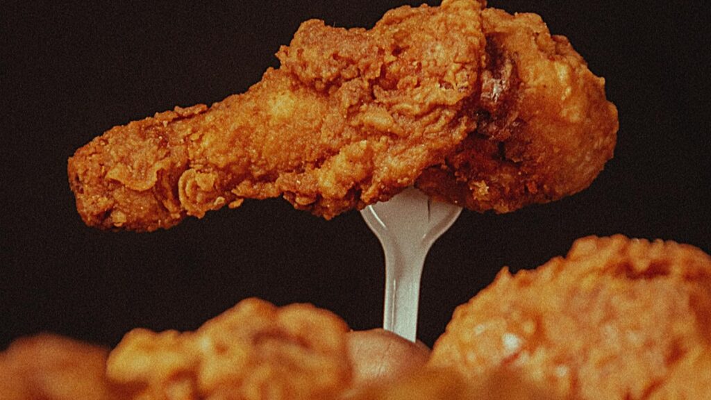 Pedazo de pollo frito en un tenedor,presentando la textura y sabor típicos de la comida rápida."Cómo Ganar Dinero en Bigo Live:Estrategias y Consejos",una guía para monetizar tu talento.